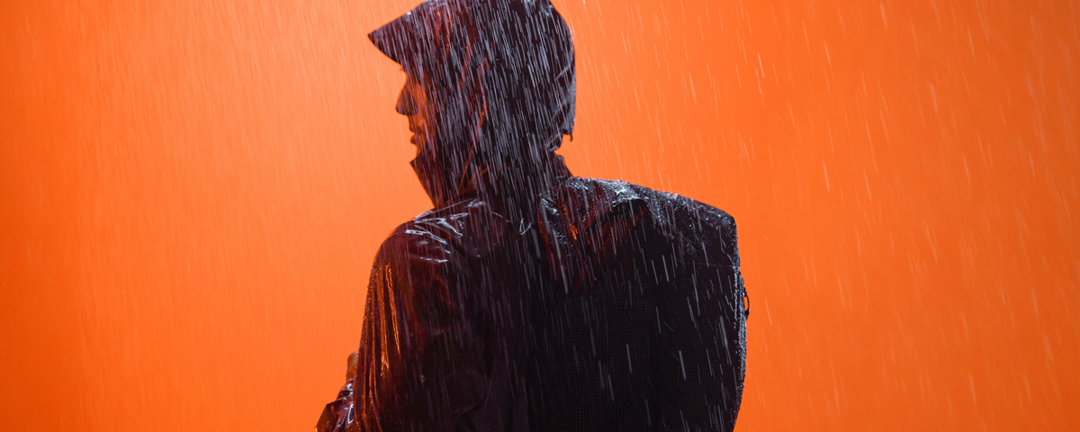 man in rain with black backpack on