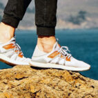 white sneakers on rock by the beach