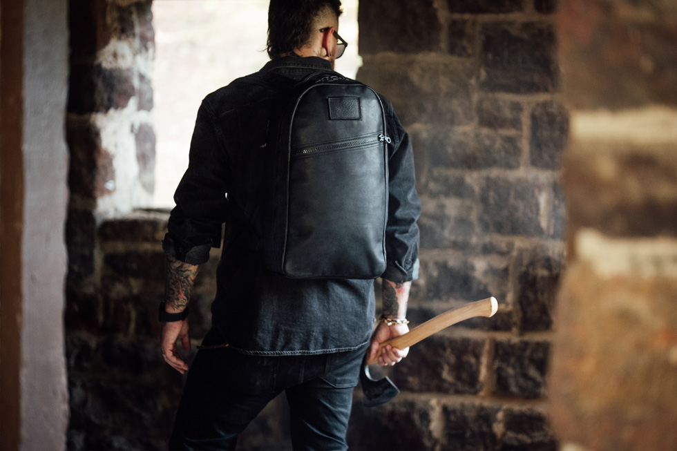 MAN WITH LEATHER BACKPACK INSIDE BRICK SHELTER